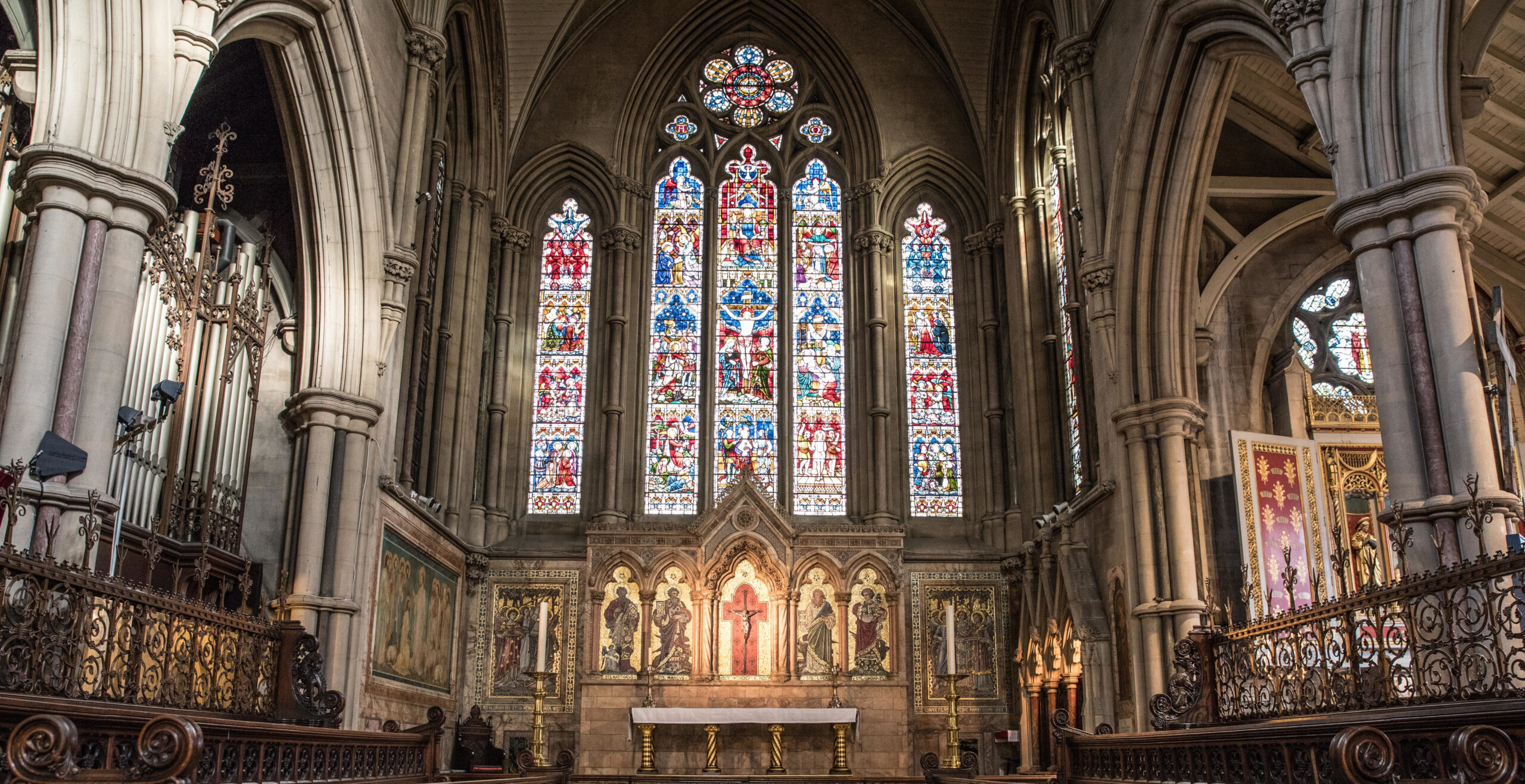 Cathedral interior with stained glass, icons, and arches