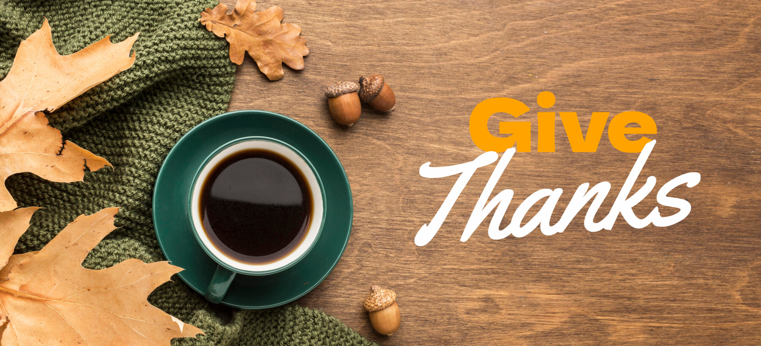 Give Thanks text with coffee in mug, leaves and acorns